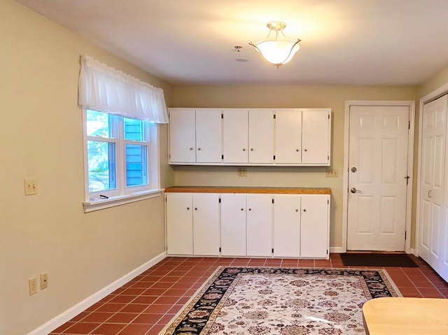 40 Willow Grove Rd, Brunswick, ME 04011 - kitchen with dark tile patterned floors and white cabinetry
