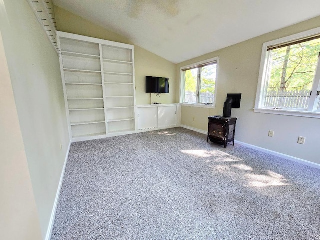 40 Willow Grove Rd, Brunswick, ME 04011 - unfurnished living room with a wood stove, vaulted ceiling, and carpet