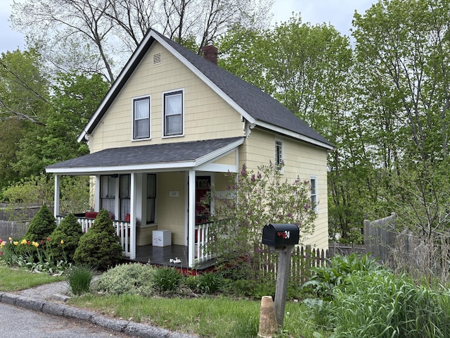 24 Glidden St, Waldoboro, ME 04572 - view of front of home featuring roof with shingles, covered porch, and a chimney