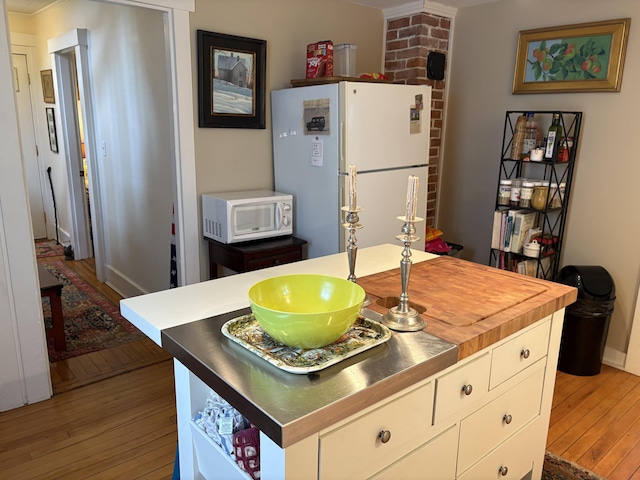 24 Glidden St, Waldoboro, ME 04572 - kitchen with white appliances, light wood-style floors, white cabinets, and a center island