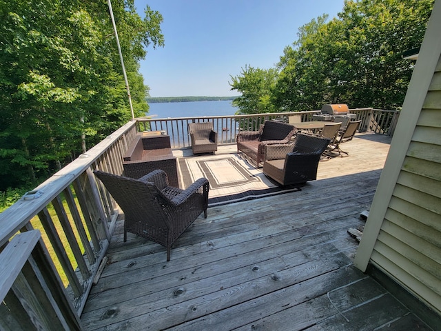 wooden deck featuring a water view, grilling area, and an outdoor hangout area