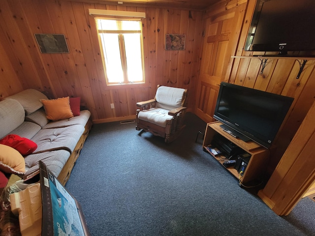 carpeted living room with wood walls