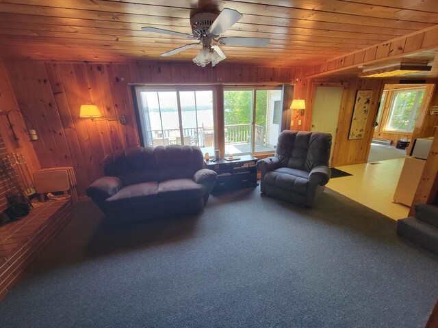 carpeted living room with ceiling fan, wooden walls, wood ceiling, and baseboard heating