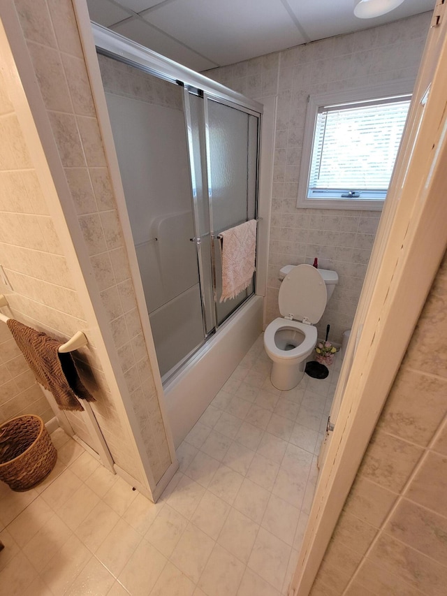 bathroom with enclosed tub / shower combo and toilet