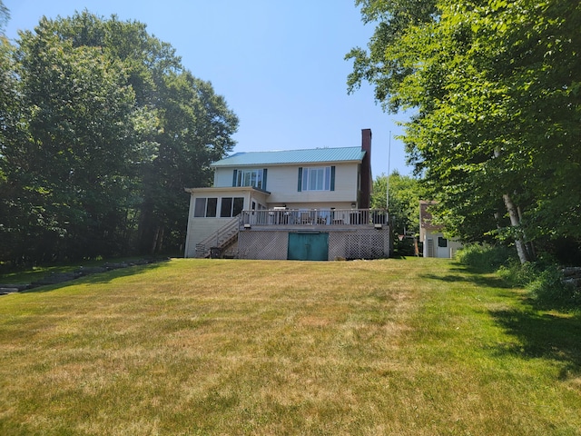 rear view of property with a lawn and a deck