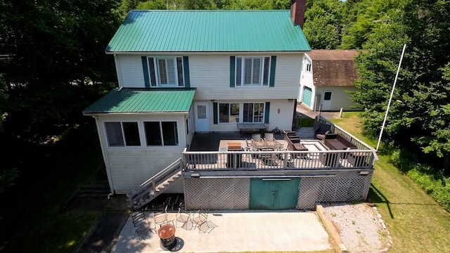 back of property with a wooden deck, an outdoor hangout area, and a patio