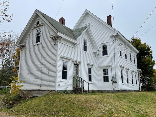 rear view of property with a lawn