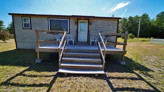 view of front of property featuring a wooden deck and a front yard