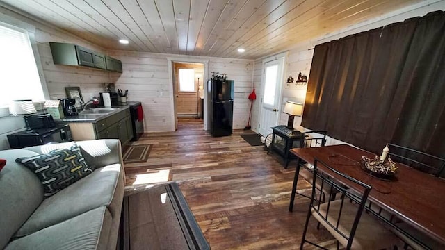 interior space with dark hardwood / wood-style flooring, wooden walls, sink, and wooden ceiling