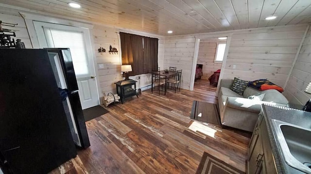 interior space featuring wood walls, wooden ceiling, sink, and dark hardwood / wood-style flooring