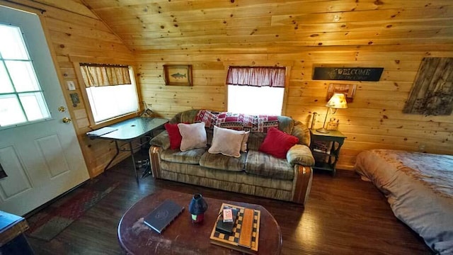 living room featuring dark wood-type flooring, a wealth of natural light, and vaulted ceiling