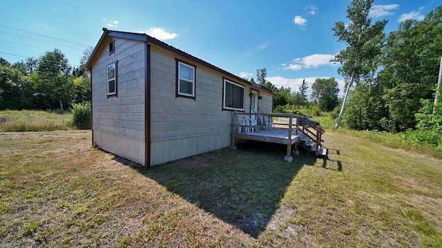 rear view of house featuring a deck and a yard