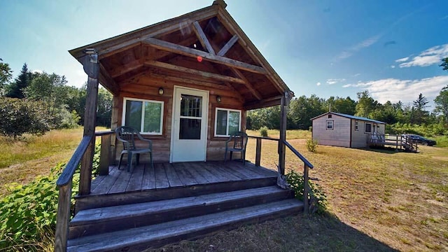 exterior space featuring an outdoor structure, a front yard, and a deck