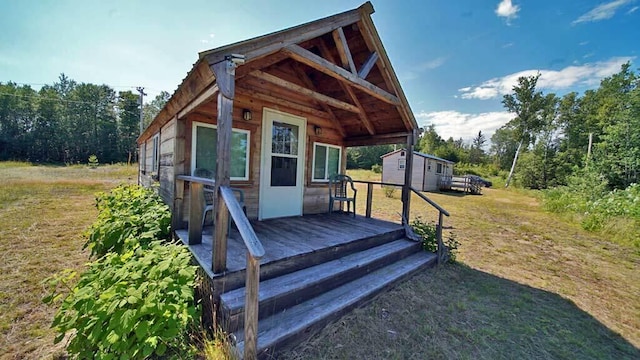 exterior space with an outdoor structure, a deck, and a front lawn