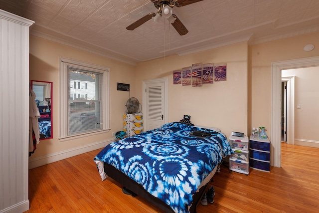 bedroom with ceiling fan, light hardwood / wood-style flooring, and ornamental molding