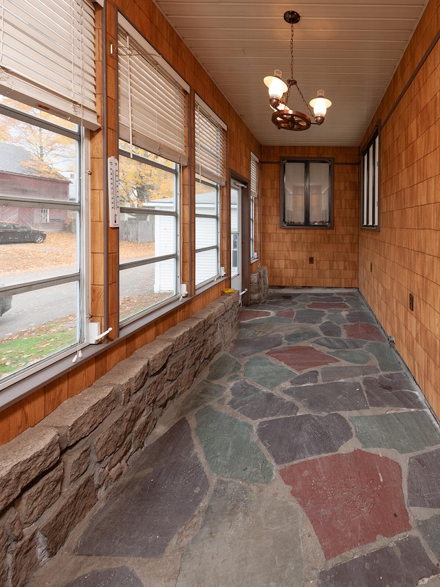 unfurnished sunroom featuring a chandelier