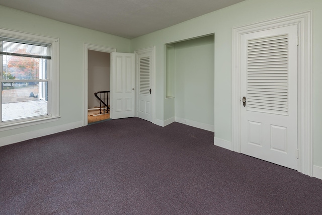 unfurnished bedroom featuring dark colored carpet