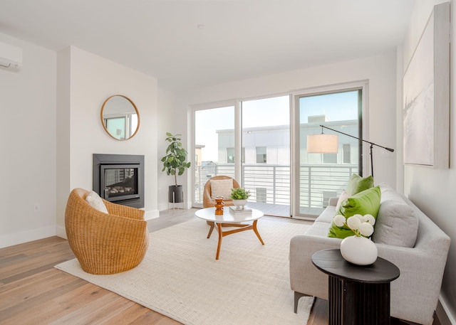 living room featuring light hardwood / wood-style floors and a wall unit AC