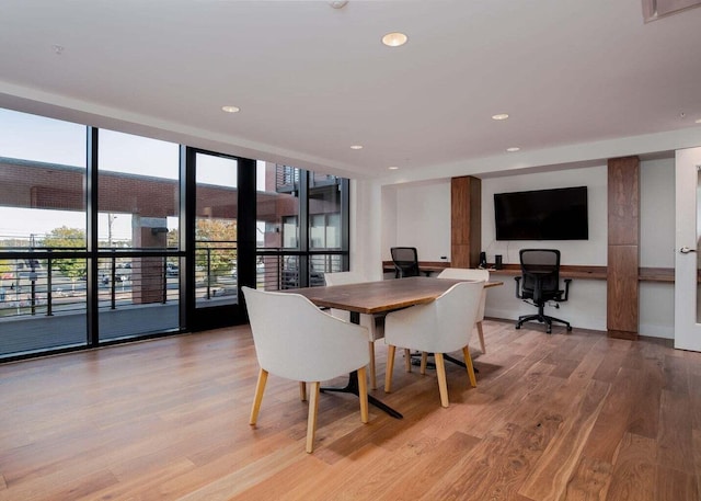 dining area featuring a wall of windows, light wood-style flooring, and recessed lighting