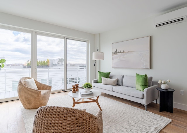 living area featuring wood finished floors, an AC wall unit, and baseboards
