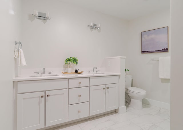 bathroom with marble finish floor, toilet, a sink, and baseboards