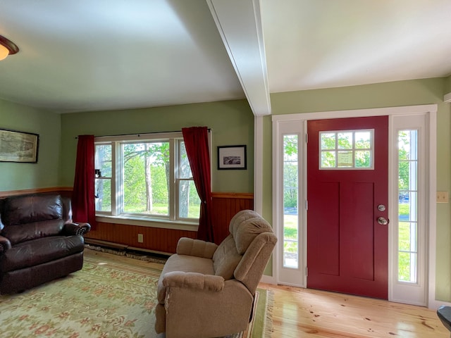 interior space with beam ceiling and light hardwood / wood-style flooring