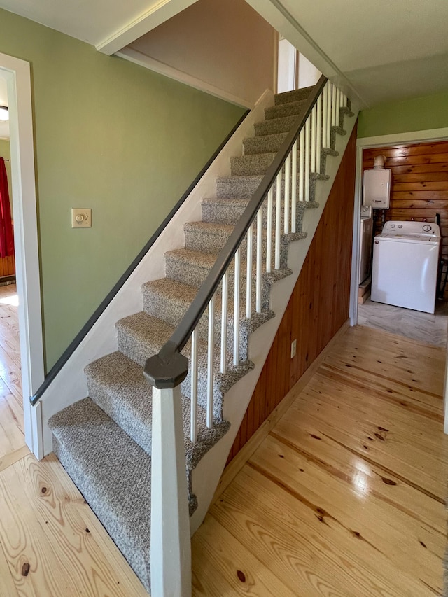 staircase featuring washer / dryer and light hardwood / wood-style flooring