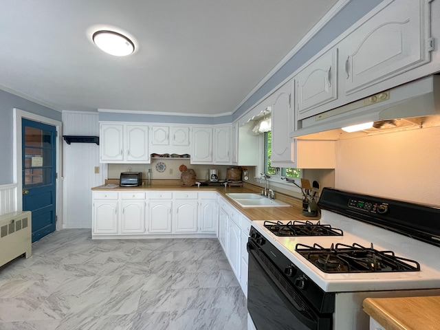 kitchen featuring light tile floors, white gas range, radiator, crown molding, and white cabinets