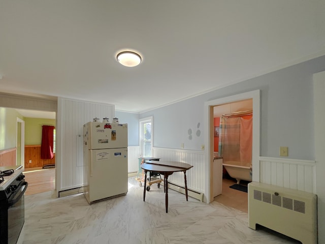 interior space featuring baseboard heating, ornamental molding, light tile floors, and radiator heating unit