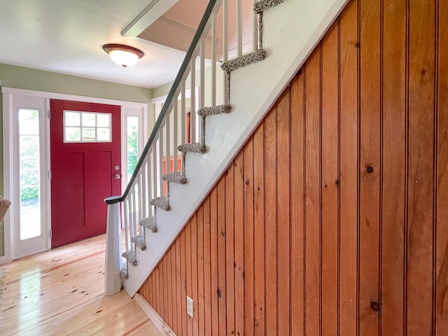 foyer with light hardwood / wood-style floors and wooden walls