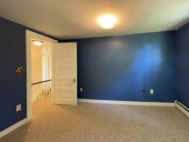 spare room with light colored carpet and a baseboard heating unit