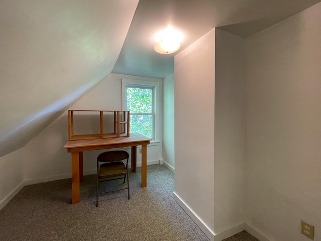 office with lofted ceiling and dark colored carpet