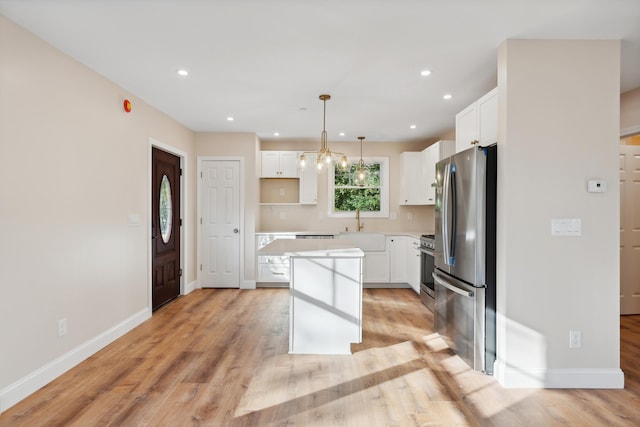 kitchen with a sink, a kitchen island, stainless steel appliances, and white cabinets