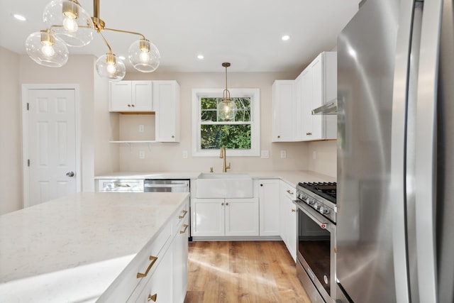 kitchen featuring white cabinetry, appliances with stainless steel finishes, a sink, and light wood-type flooring