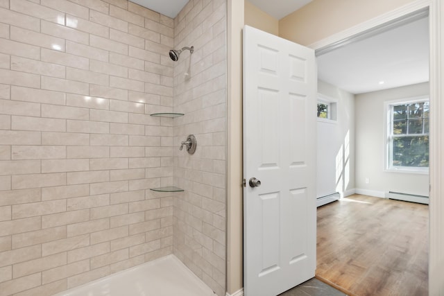 full bathroom with baseboards, a baseboard heating unit, and tiled shower