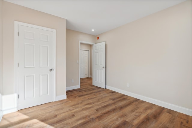 unfurnished bedroom with baseboards, recessed lighting, and light wood-style flooring