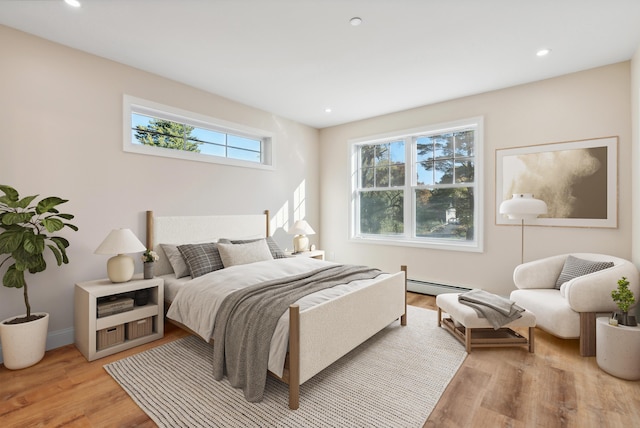 bedroom featuring light wood-type flooring, recessed lighting, and baseboard heating