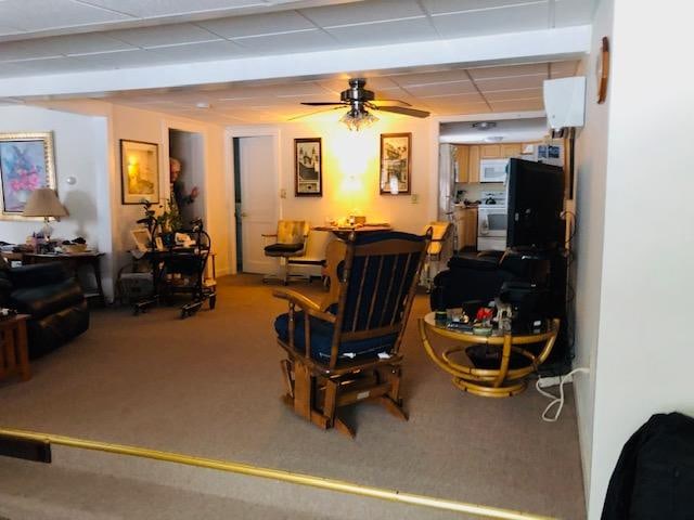 carpeted living room featuring a paneled ceiling and ceiling fan