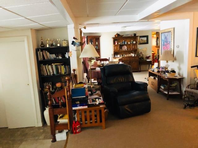 sitting room featuring a paneled ceiling and light colored carpet