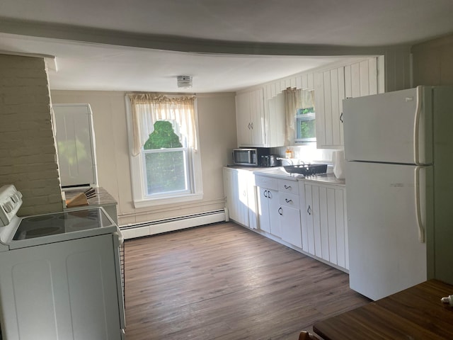 kitchen with hardwood / wood-style flooring, a healthy amount of sunlight, white appliances, and a baseboard heating unit