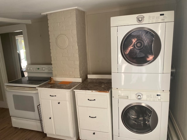 laundry area featuring dark hardwood / wood-style floors and stacked washer and dryer