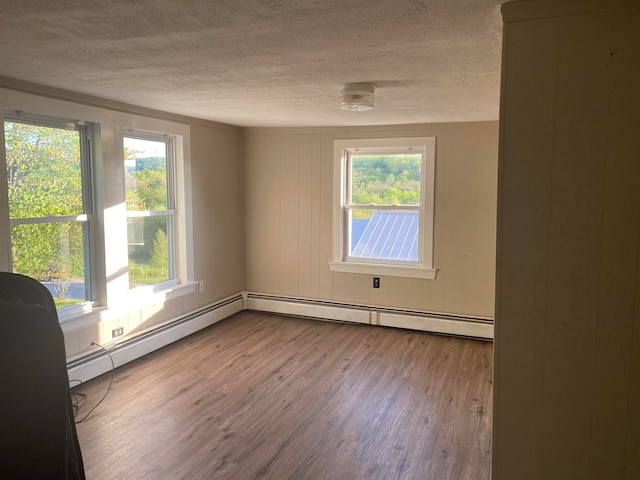 unfurnished room with baseboard heating, a textured ceiling, and hardwood / wood-style flooring