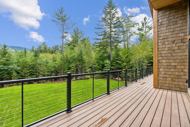 wooden terrace featuring a lawn