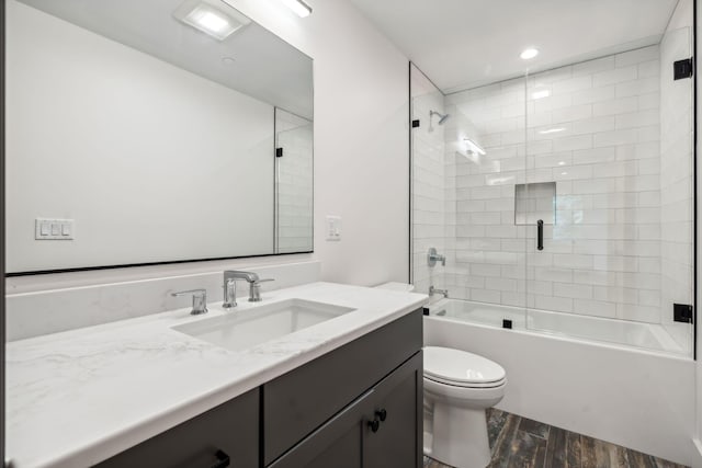 full bathroom with vanity, wood-type flooring, enclosed tub / shower combo, and toilet