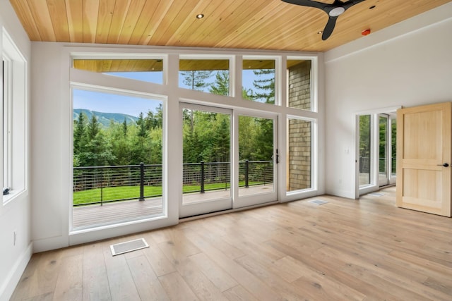 entryway featuring a mountain view, a wealth of natural light, wooden ceiling, and light wood-type flooring