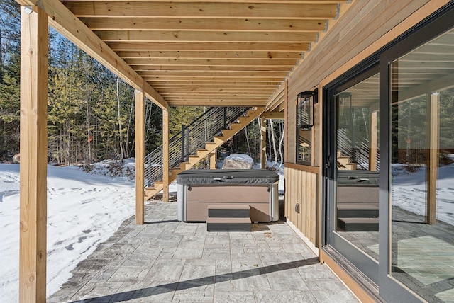 snow covered patio with a hot tub