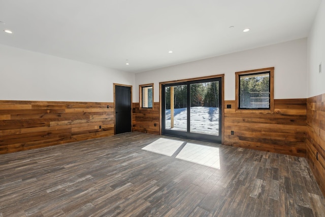 unfurnished room featuring dark wood-type flooring and wood walls