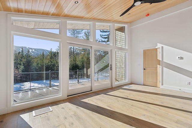 doorway to outside featuring hardwood / wood-style flooring, ceiling fan, a mountain view, and wood ceiling