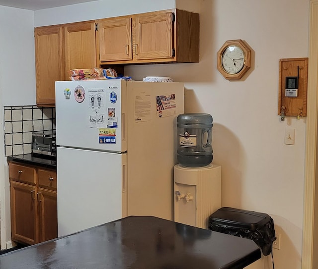 kitchen with white fridge and tasteful backsplash