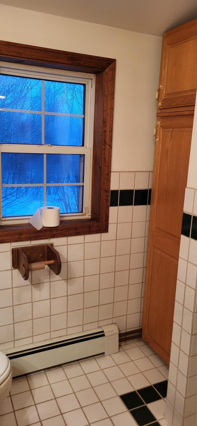 bathroom with tile patterned floors, tile walls, toilet, and a baseboard radiator